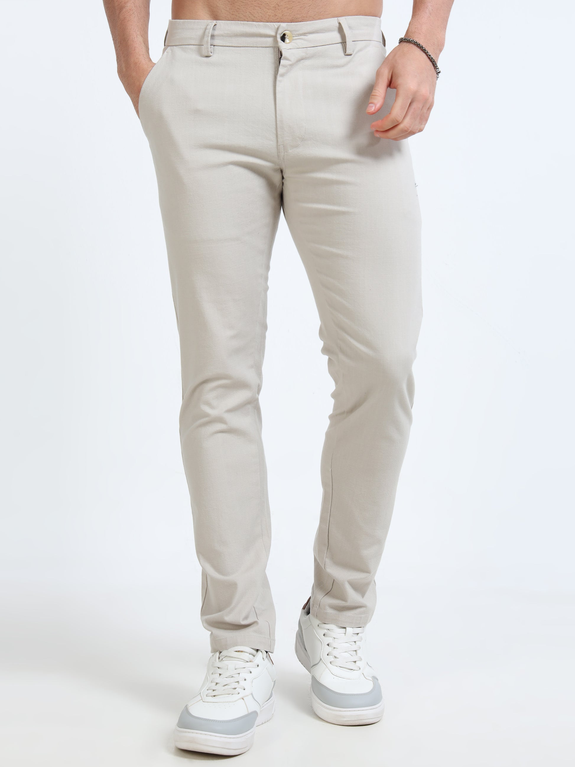 Person wearing light gray pants and white sneakers on a white background
