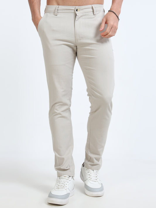Person wearing light gray pants and white sneakers on a white background