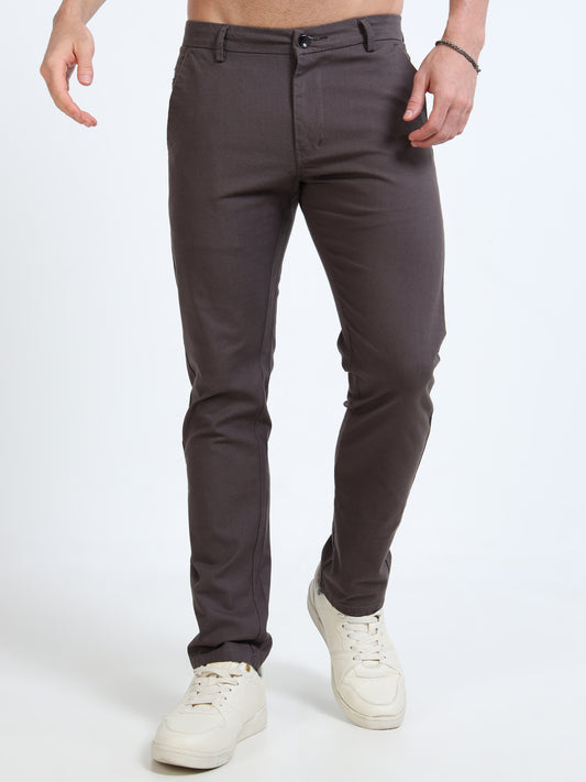 Person wearing dark gray pants and white sneakers on a white background