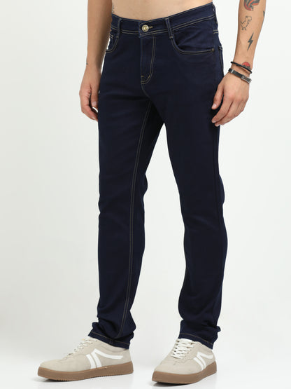 Person wearing dark blue jeans on a white background