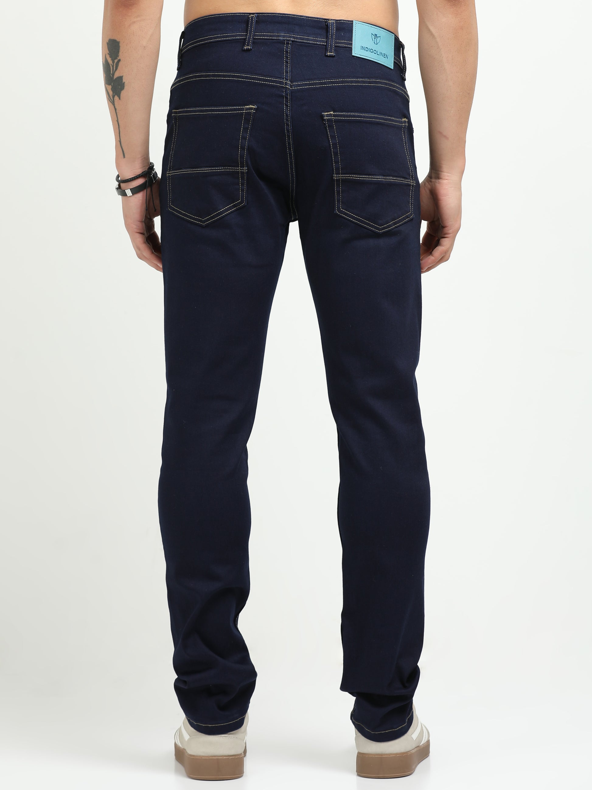 Person wearing dark blue jeans on a white background