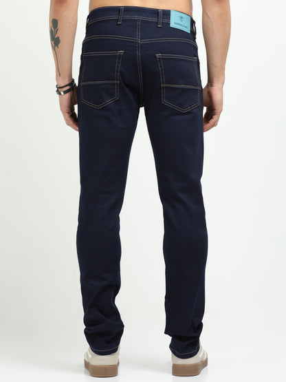 Person wearing dark blue jeans on a white background